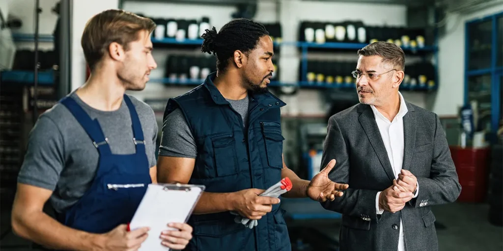 African American Auto Mechanic His Coworker Communicating With Their Manager Repair Shop